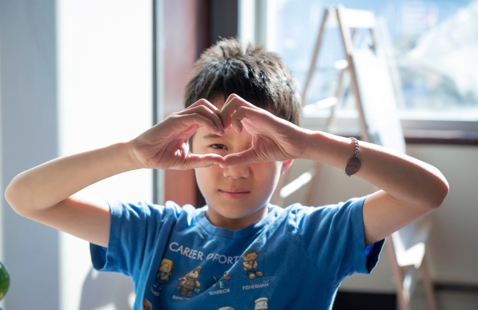 Young boy with heart hands 