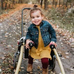 Ivy, walking through a forest trail using an assistive device