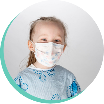 Young girl wearing a hospital gown and face mask