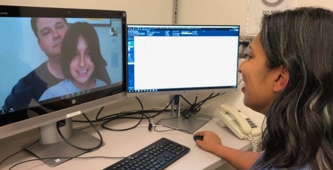 Emergency Department physician providing virtual care to a family using a computer and webcam