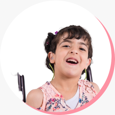Photo of a young girl in a wheelchair smiling at the camera