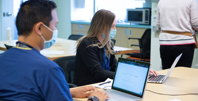 Image of CHEO staff wearing masks and participating in virtual rounds on a laptop