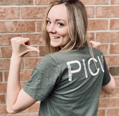 Femme blonde portant un t-shirt avec le texte PICU (UPSI)