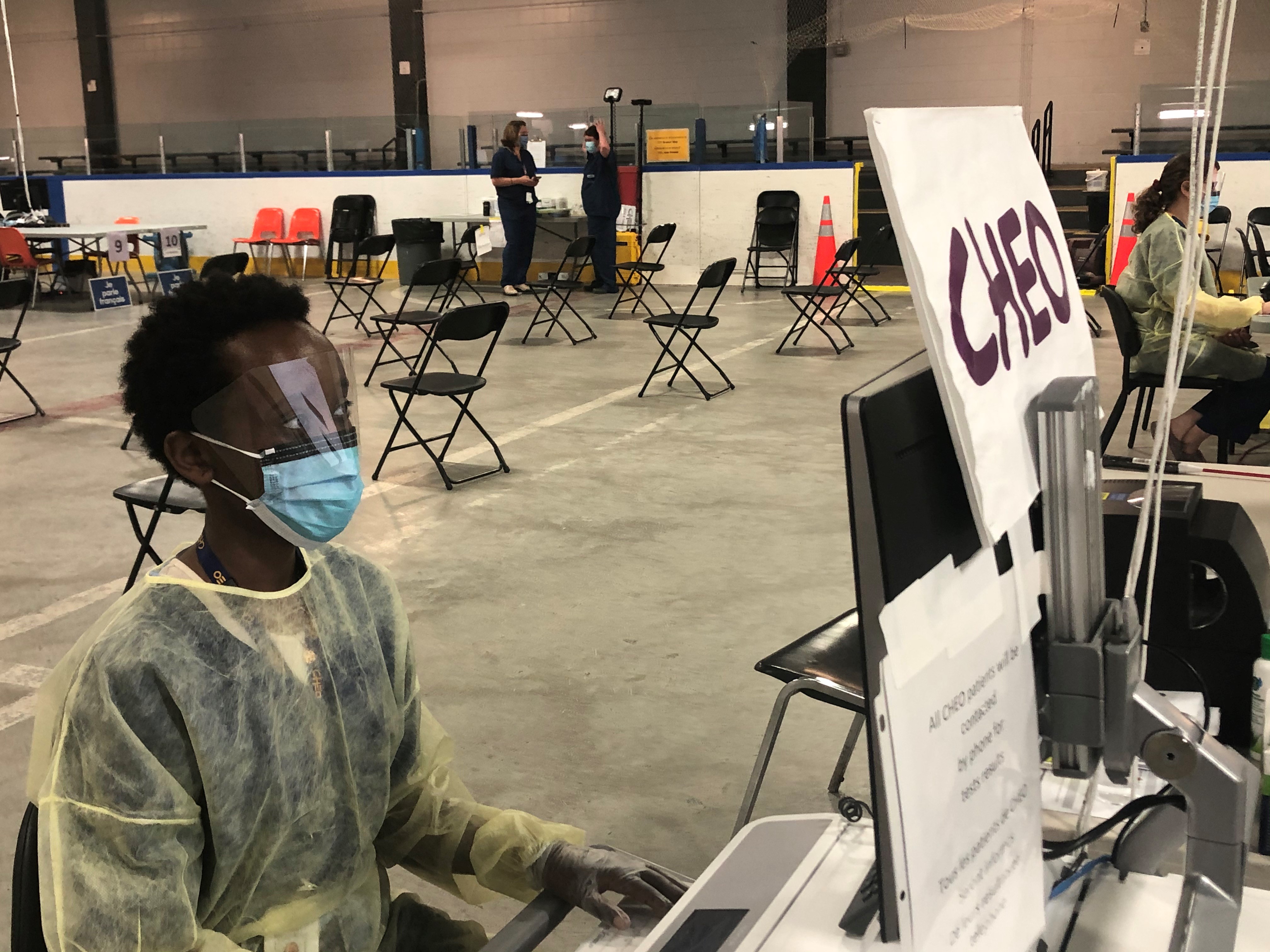 Image of a women dressed in PPE typing at a computer at the Brewer Assessment Centre.