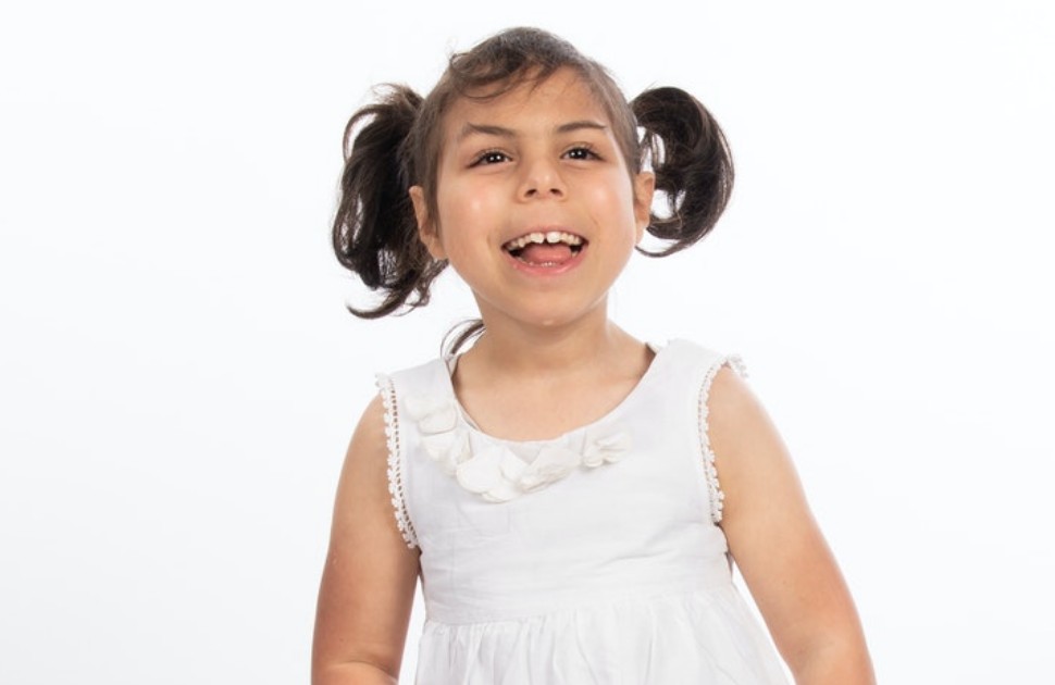 Little girl smiling in a white dress