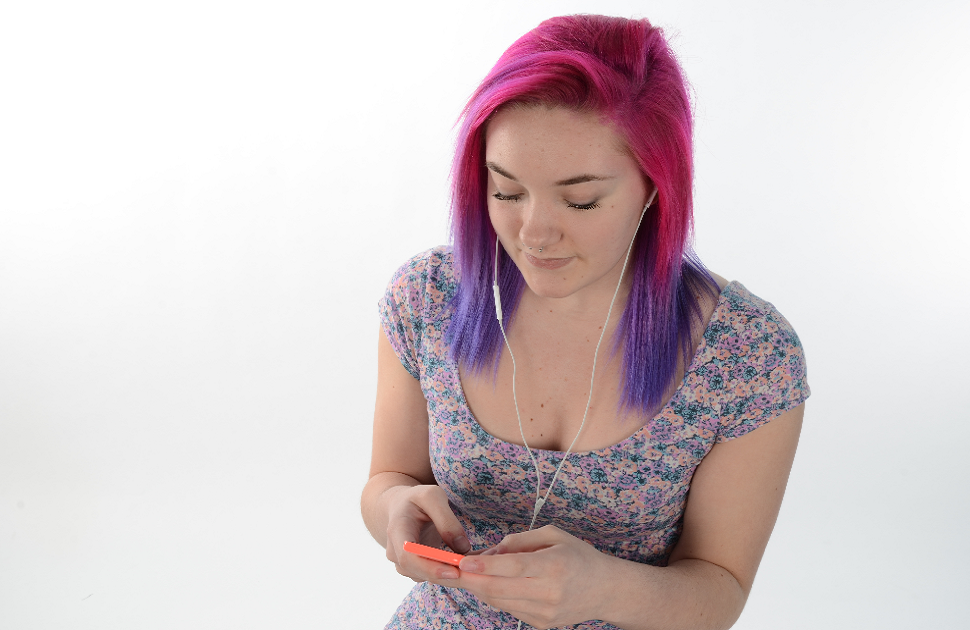 Girl with coloured hair looking at cellphone