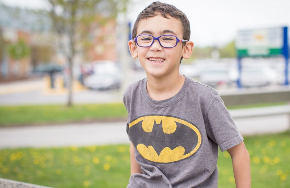 Boy with glasses smiling at camera
