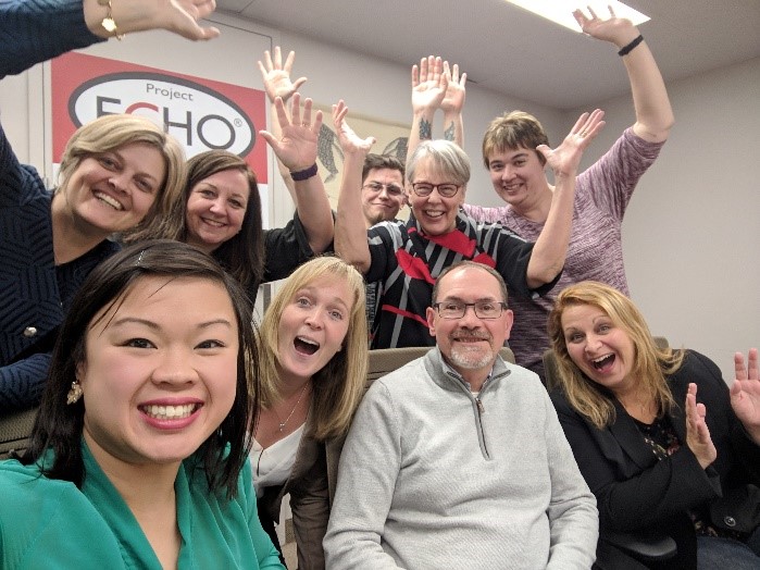 Group of people smiling and holding their hands in the air