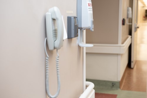 An access card station, telephone and hand sanitizer dispenser all attached to a wall by the NICU entrance.