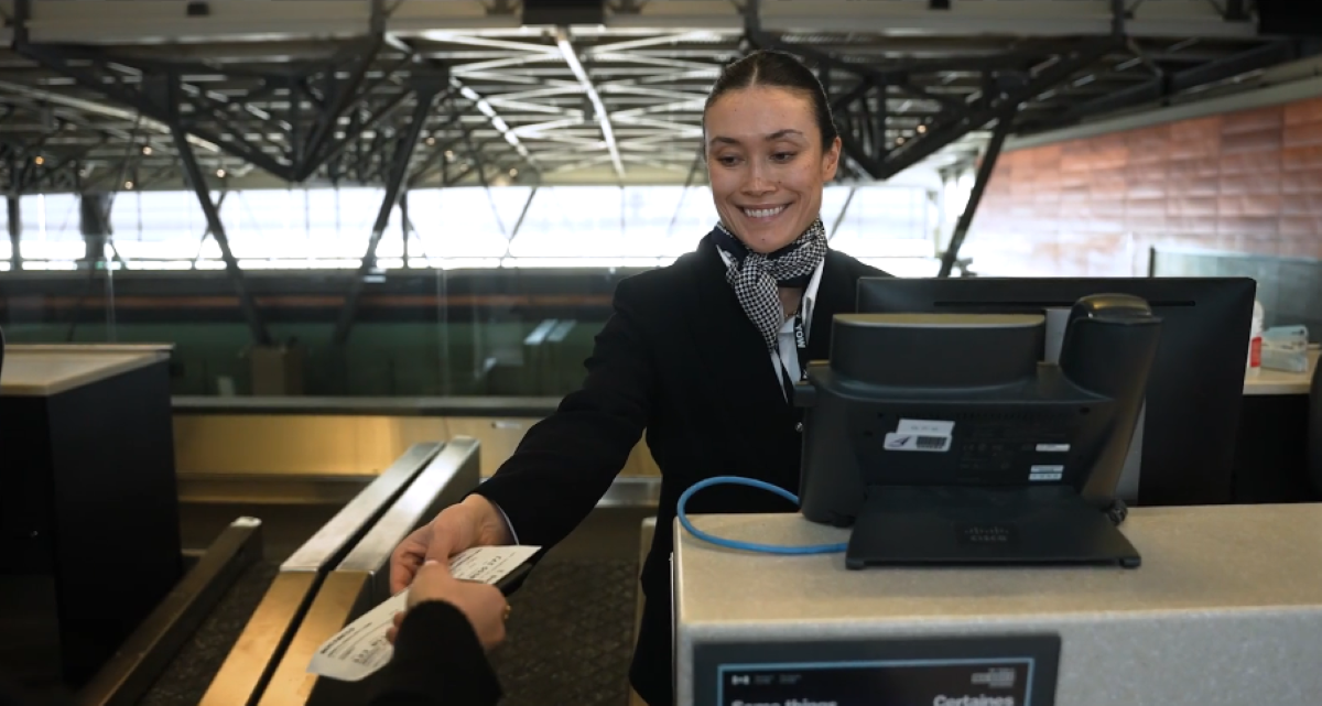 airport worker hands ticket to customer