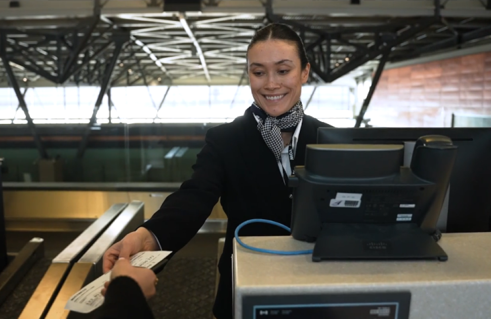 airport worker hands ticket to customer