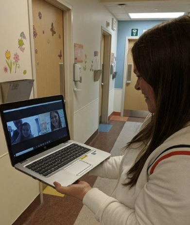 CHEO staff holding a laptop and meeting virtually with a family