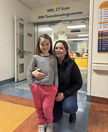 mother and daughter pose in front of MRI clinic