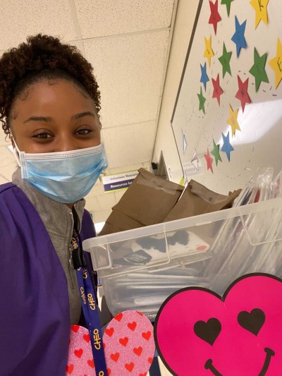 CHEO Volunteer in purple vest and face mask