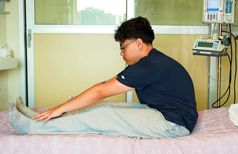 boy stretches on hospital bed