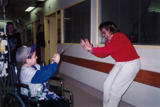 Strider, 9, is in a wheelchair and squirts a nurse with water-filled syringe.