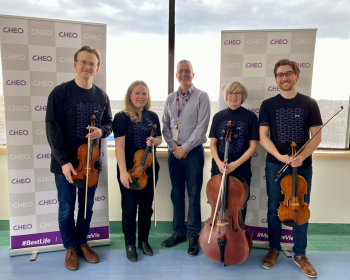 nac musicians stand with cheo nurse in hospital hallway