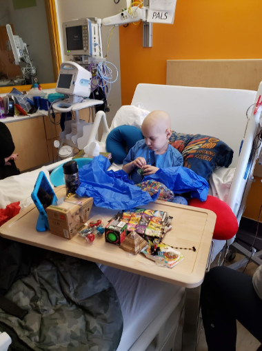Ollie after his first relapse. He is in a hospital bed surrounded by toys.