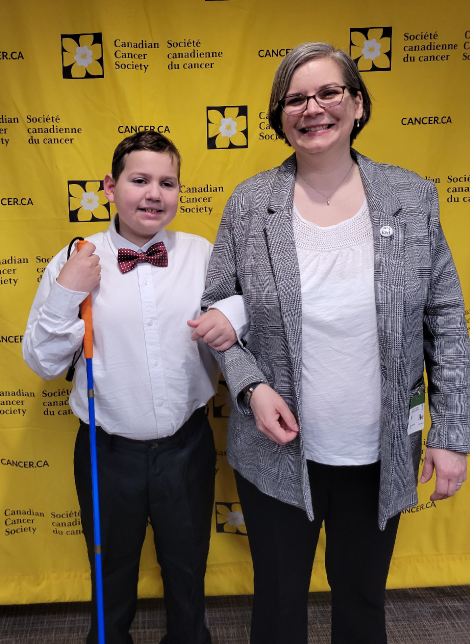 Ollie et Dawn posent devant la Société canadienne du cancer en toile de fond lors de leur Journée sur la Colline.