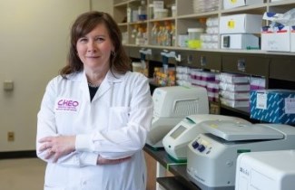 cheo doctor stands in lab with arms crossed