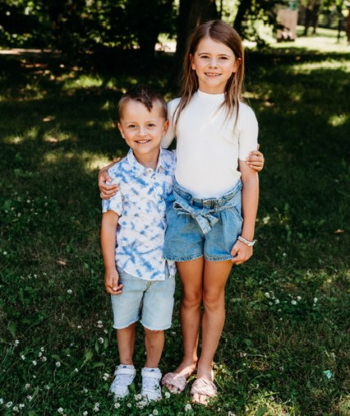 brother and sister posing for camera in a park 