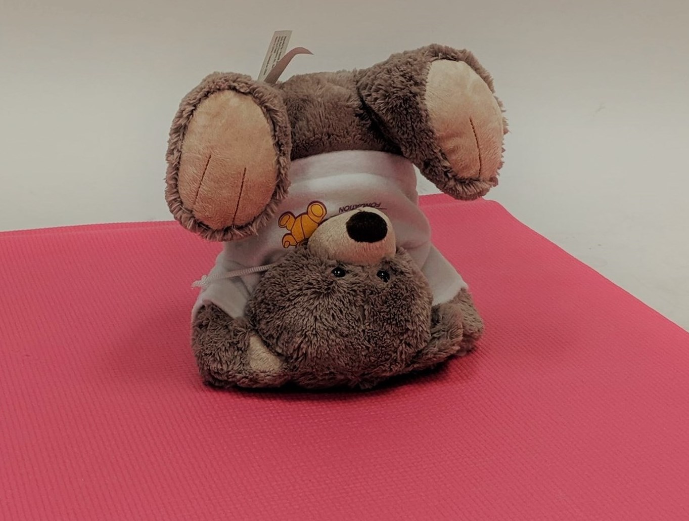 CHEO bear doing a headstand on a yoga mat