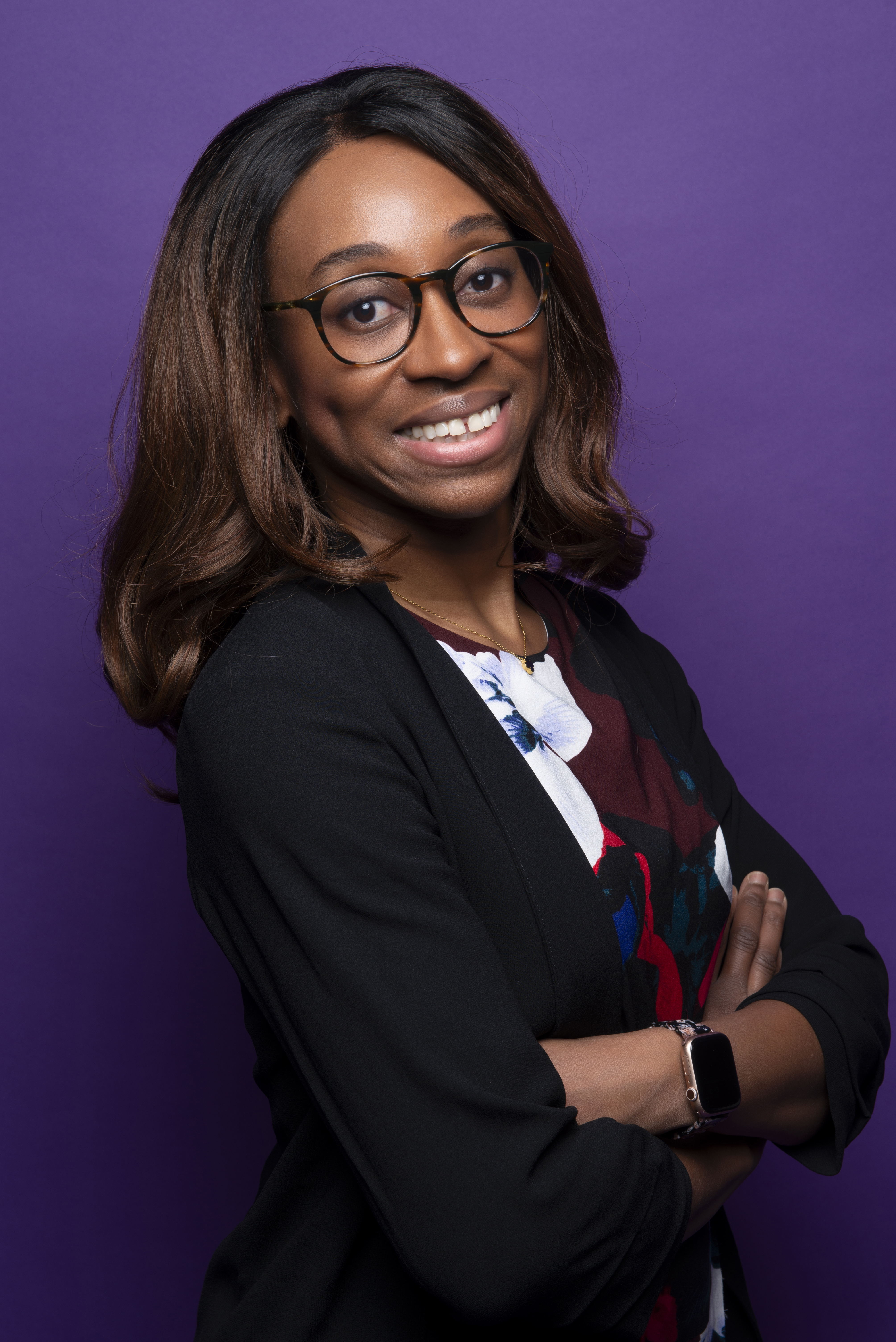 Headshot of Dr. Simpson in a black blazer against a purple background