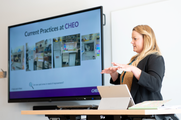 nurse presents at conference with powerpoint on screen