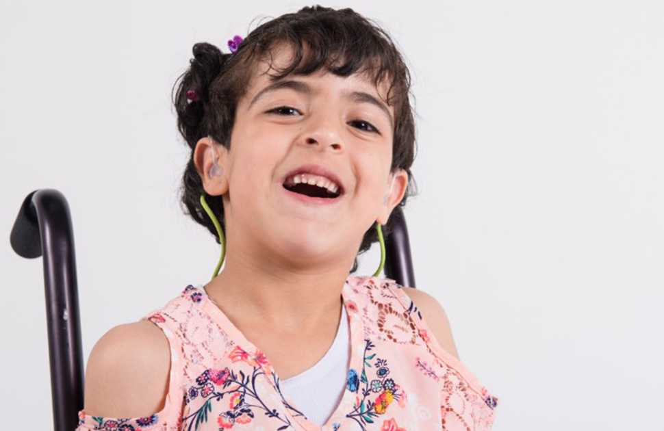 Girl in wheelchair smiling at camera