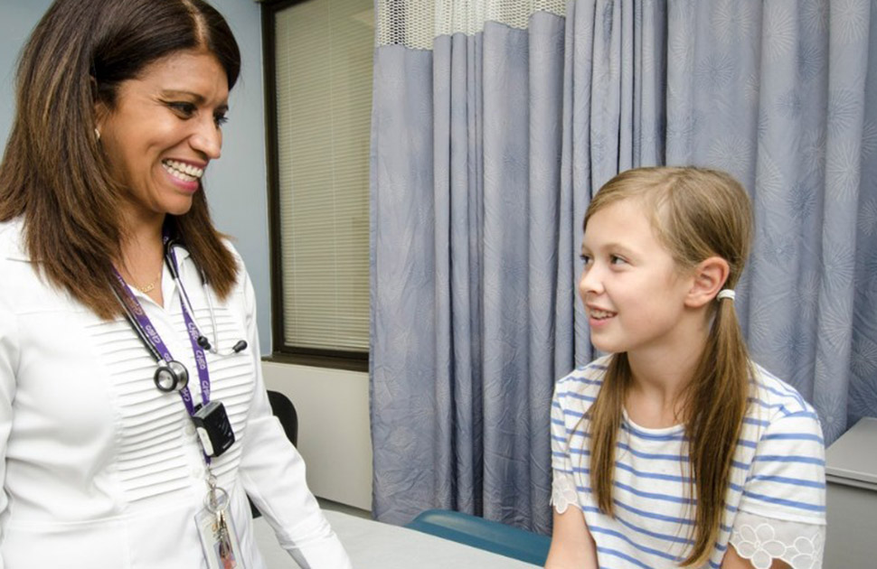 Child and physician smiling at each other