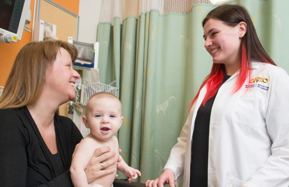 Physician smiling at mother with baby in her arms