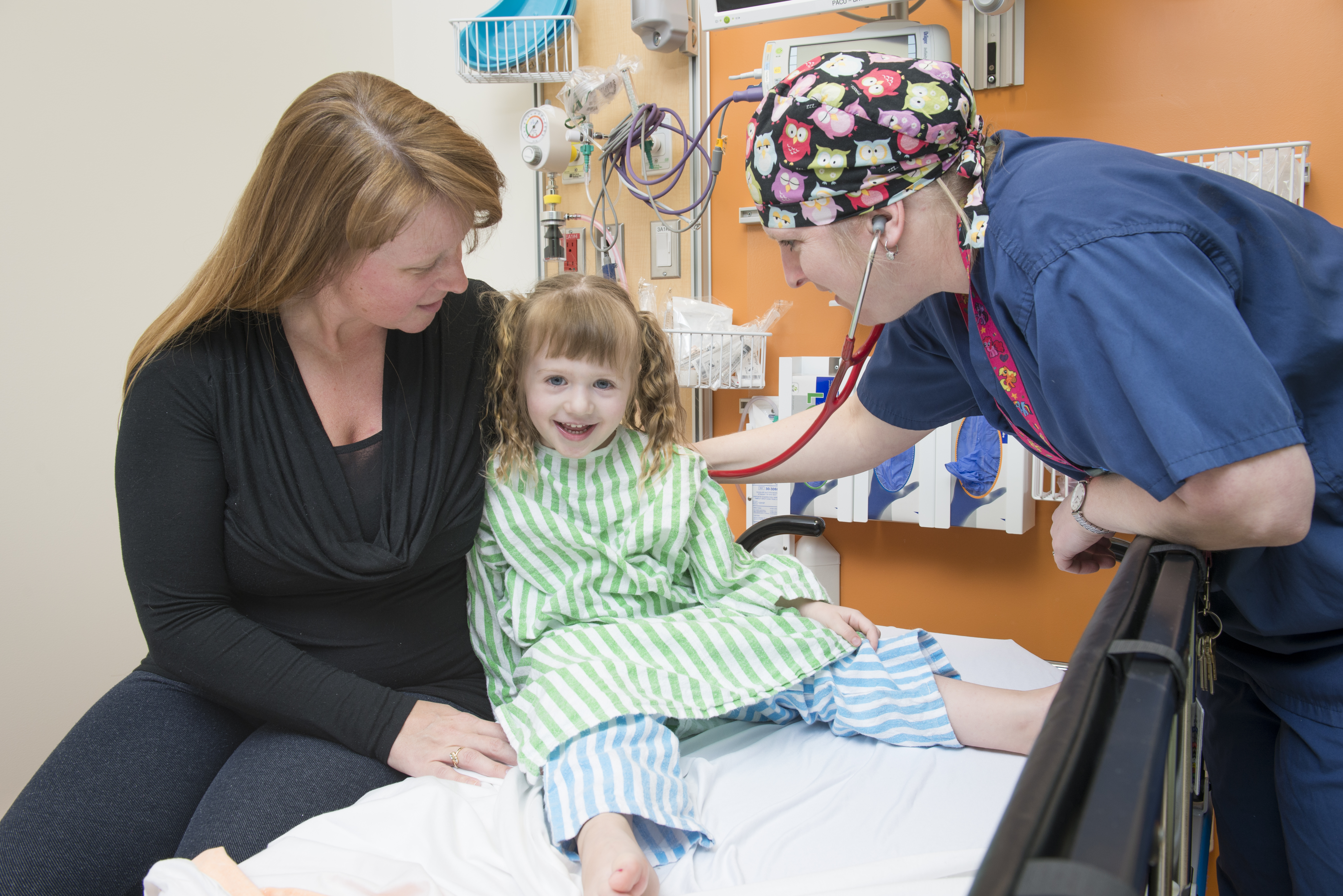 Young girl with mother being examined by physician