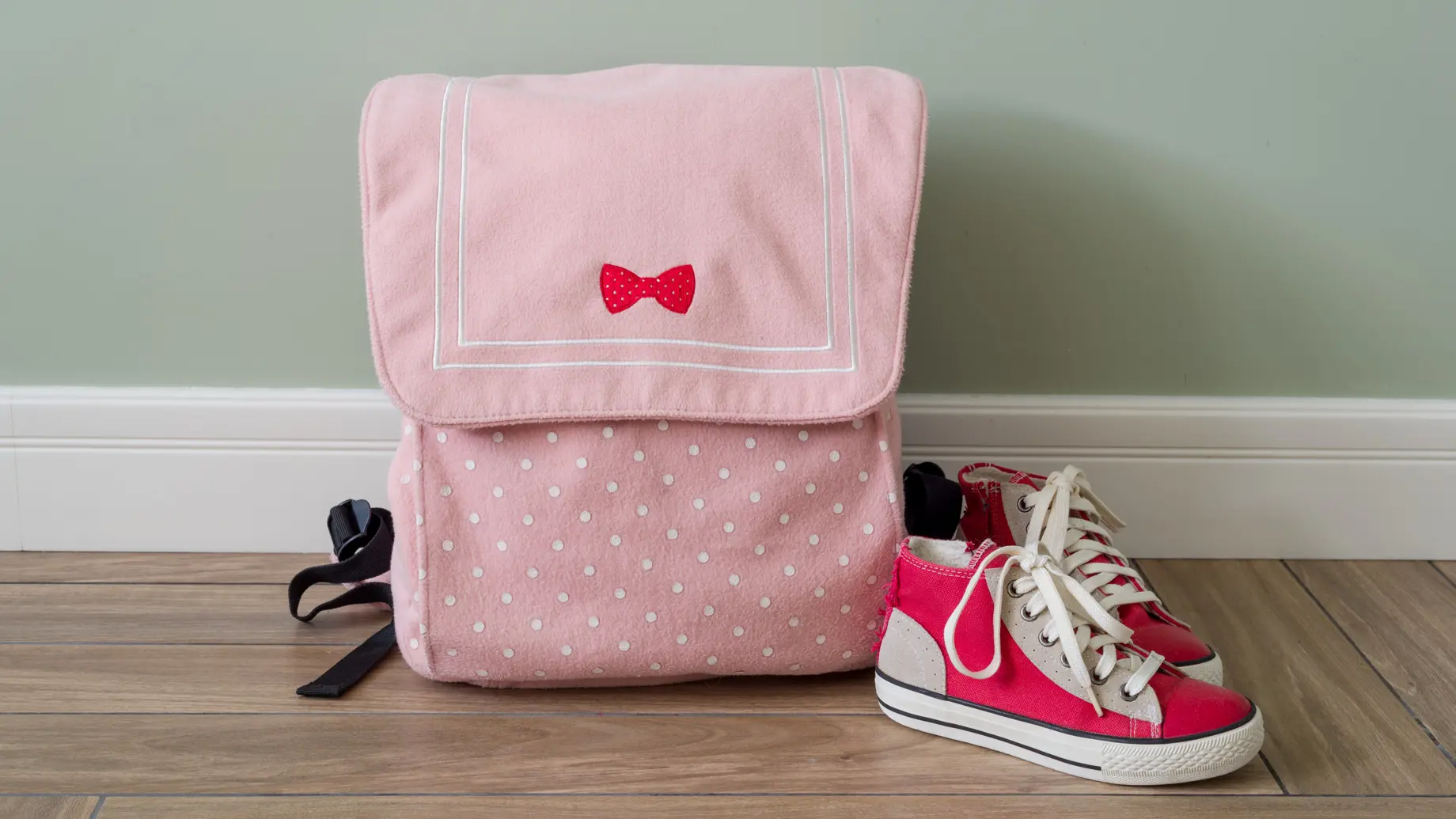 un sac à dos et des chaussures roses