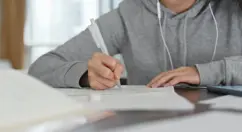 un adolescent qui prend des notes